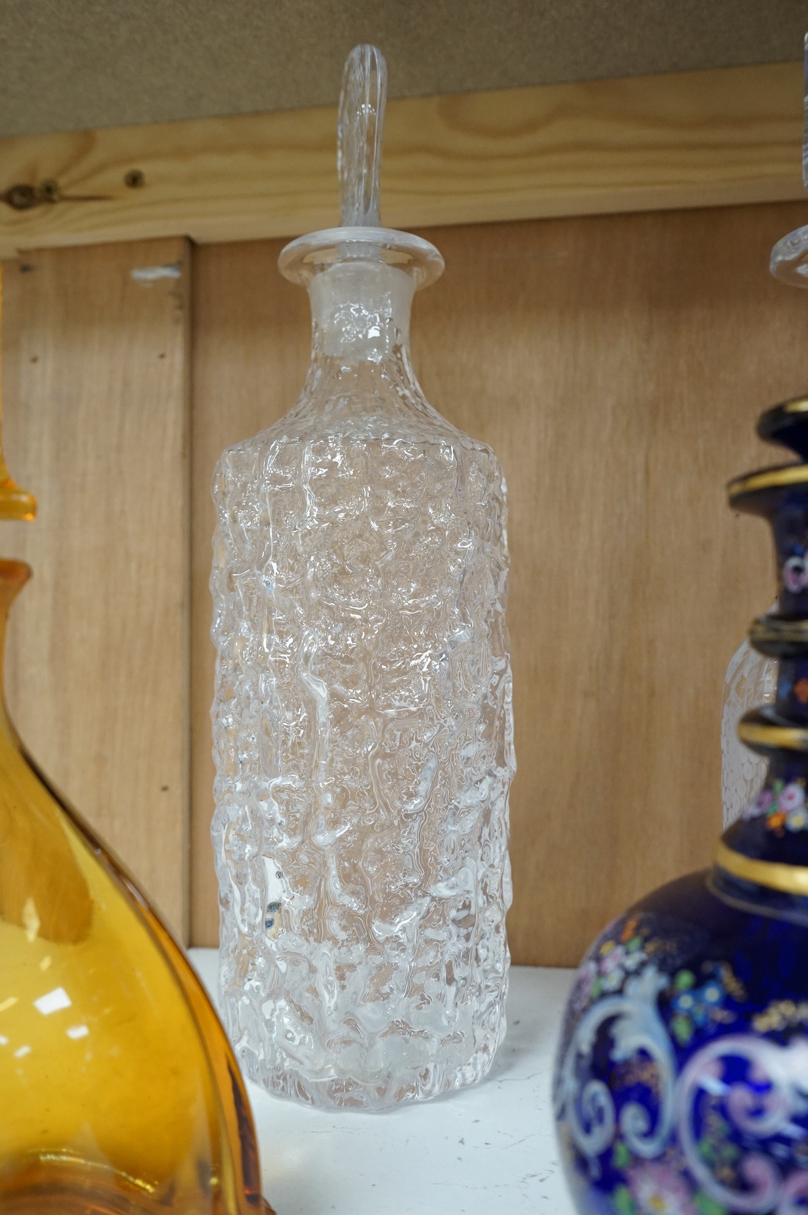 A Whitefriars ‘bark’ effect clear glass decanter with stopper and six other items of glassware, tallest 33cm. Condition - fair to good
